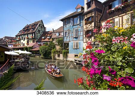 Tourists sitting in a boat on a canal, Colmar, France, elevated view View Large Photo Image Stock Photograph - Tourists sitting in a boat on a canal, Colmar, France, elevated view . Fotosearch