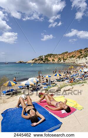 Tourists sunbathing on beach, Cala d'Hort, Ibiza, Balearic Islands, Spain View Large Photo Image Stock Image - Tourists sunbathing on beach, Cala d'Hort, Ibiza, Balearic Islands, Spain . Fotosearch