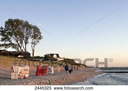 Tourists walking at beach during dusk View Large Photo Image Stock Image - Tourists walking at beach during dusk . Fotosearch