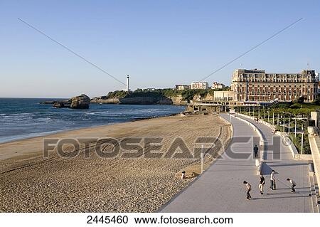 Tourists walking on promenade with hotel and lighthouse in background, Hotel Du Palais, Biarritz, Pyrenees-Atlantiques, Aquitaine, France View Large Photo Image Stock Image - Tourists walking on promenade with hotel and lighthouse in background, Hotel Du Palais, Biarritz, Pyrenees-Atlantiques, Aquitaine, France . Fotosearch