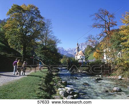 Tourists walking on riverside with church in background, St. Sebastian Church, Ramsau bei Berchtesgaden, Berchtesgadener Land, Bavaria, Germany View Large Photo Image Stock Image - Tourists walking on riverside with church in background, St. Sebastian Church, Ramsau bei Berchtesgaden, Berchtesgadener Land, Bavaria, Germany . Fotosearch