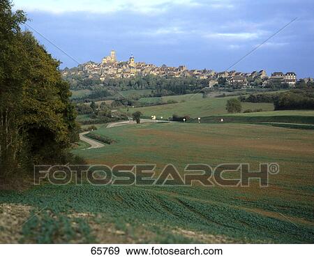 Town on landscape under cloudy sky, Vezelay, Burgundy, France  View Large Photo Image Stock Photo - Town on landscape under cloudy sky, Vezelay, Burgundy, France . Fotosearch