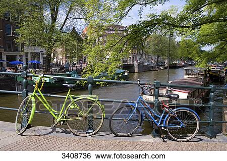 Stock Photograph - Two bicycles on a bridge in Amsterdam, Netherlands . Fotosearch