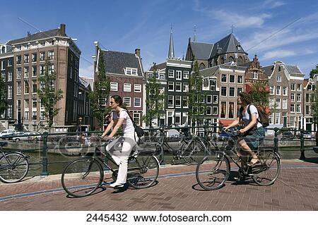 Two women cycling along canal, Amsterdam, Netherlands View Large Photo Image Stock Image - Two women cycling along canal, Amsterdam, Netherlands . Fotosearch