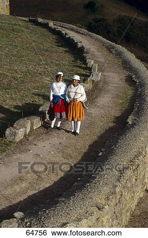 Stock Photograph - Two women in traditional clothing on dirt path, Ingapirca, Canar Province, Ecuador . Fotosearch