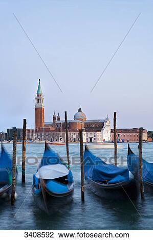 Stock Image - View of San Giorgio Maggiore, moored gondolas in the foreground, Venice, Italy . Fotosearch