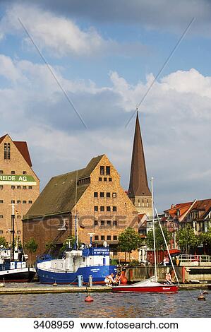 View of warehouses and St. Peter's Church, boats on a river in the foreground, Rostock, Germany View Large Photo Image Stock Photo - View of warehouses and St. Peter's Church, boats on a river in the foreground, Rostock, Germany . Fotosearch