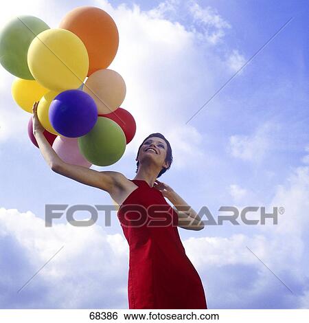 Woman in red skirt holding balloons, low angle view View Large Photo Image Stock Photograph - Woman in red skirt holding balloons, low angle view . Fotosearch