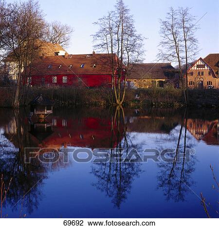 Bare trees and houses reflected in lake, Mecklenburg-West Pomerania, Germany View Large Photo Image Stock Image - Bare trees and houses reflected in lake, Mecklenburg-West Pomerania, Germany . Fotosearch