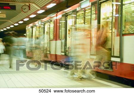 Picture - Blurred view of passengers boarding suburban train, Germany . Fotosearch