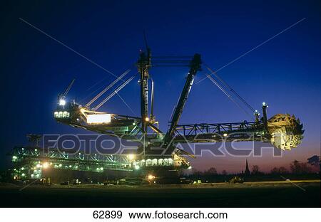 Bucket wheel excavator lit up at open pit mine, Garzweiler, Germany View Large Photo Image Stock Photo - Bucket wheel excavator lit up at open pit mine, Garzweiler, Germany . Fotosearch