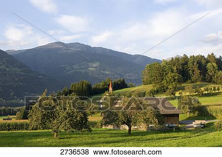 Stock Photo - Church and house on hill, Amlach, Drautal, Carinthia, Austria . Fotosearch