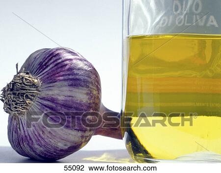 Stock Image - Close-up of bottle of olive oil and garlic . Fotosearch