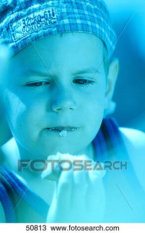 Stock Image - Close-up of boy eating cookie . Fotosearch
