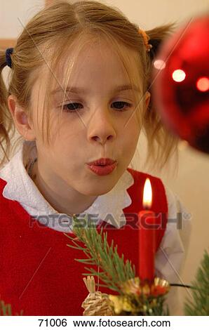 Close-up of girl blowing christmas candle View Large Photo Image Stock Photograph - Close-up of girl blowing christmas candle . Fotosearch