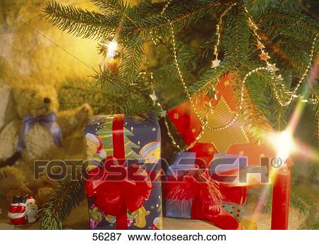 Close-up of lit Christmas candle with Christmas gifts View Large Photo Image Stock Photo - Close-up of lit Christmas candle with Christmas gifts . Fotosearch