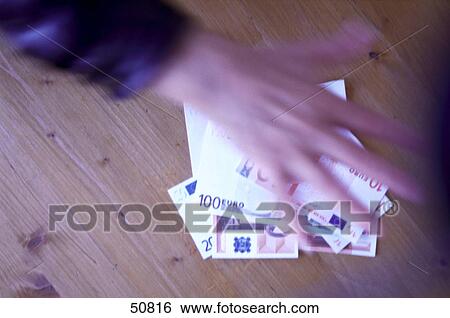 Close-up of person's hand reaching for European Union currency View Large Photo Image Stock Photograph - Close-up of person's hand reaching for European Union currency . Fotosearch