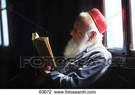 Stock Image - Close-up of senior rabbi reading religious book . Fotosearch