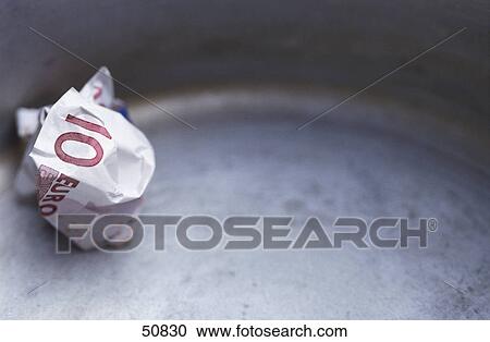 Stock Image - Close-up of ten Euro banknote in garbage bin . Fotosearch
