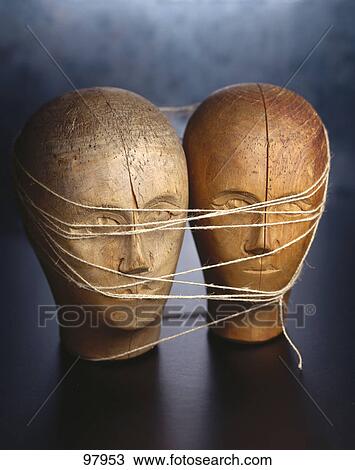 Stock Image - Close-up of two cracked wooden face tied up with threads . Fotosearch