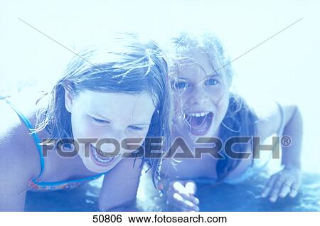 Close-up of two teenage girls playing in water on beach View Large Photo Image Stock Photograph - Close-up of two teenage girls playing in water on beach . Fotosearch