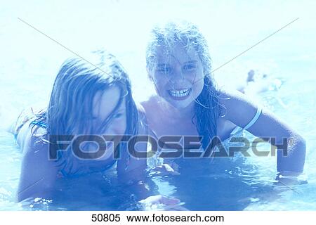 Close-up of two teenage girls playing in water on beach View Large Photo Image Stock Photography - Close-up of two teenage girls playing in water on beach . Fotosearch