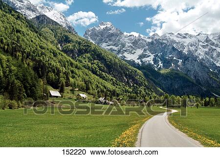 Country road passing through meadow along with mountains, Slovenia View Large Photo Image Stock Image - Country road passing through meadow along with mountains, Slovenia . Fotosearch