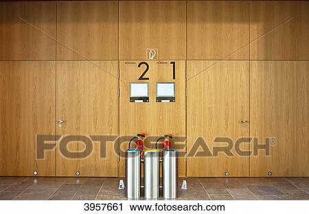 Stock Image - Fire extinguishers and wastebins in front of auditorium in the Goethe University Frankfurt, Germany . Fotosearch