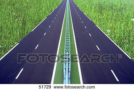 Highway running through meadow field View Large Photo Image Stock Photo - Highway running through meadow field . Fotosearch