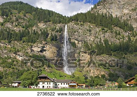Houses in village with waterfall in background, Maltatal, Austria View Large Photo Image Stock Image - Houses in village with waterfall in background, Maltatal, Austria . Fotosearch