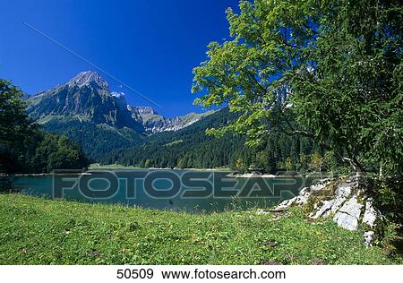 Stock Photo - Lake in front of mountain, Swiss Alps, Switzerland . Fotosearch