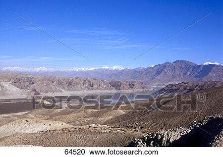 Stock Image - Lake surrounded by mountain range, Hindukush Mountains, Afghanistan . Fotosearch