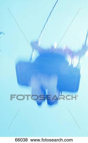 Low angle view of child swinging on chain swing View Large Photo Image Stock Photo - Low angle view of child swinging on chain swing . Fotosearch