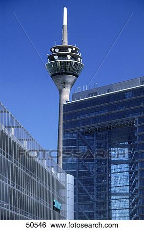 Stock Photograph - Low angle view of communication tower with office buildings, Neuer Zollhof, Dusseldorf, North Rhine-Westphalia, Germany . Fotosearch