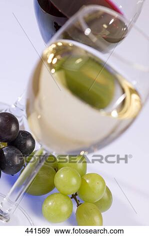 Low angle view of glass of white wine and grapes View Large Photo Image Stock Photo - Low angle view of glass of white wine and grapes . Fotosearch