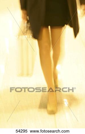 Stock Photography - Low section of young woman walking downstairs with briefcase . Fotosearch