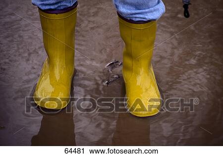 Stock Image - Low section view of person wearing galoshes . Fotosearch