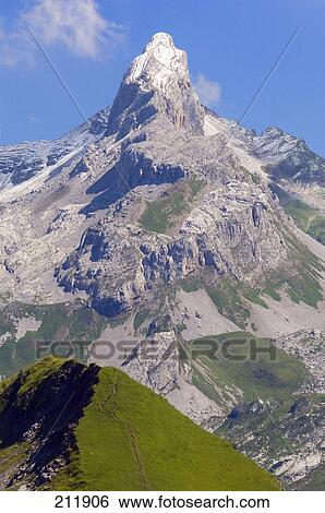 Stock Photograph - Mountain peak against blue sky, Canton Schwyz, Switzerland . Fotosearch