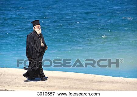 Orthodox priest strolling on waterside promenade, Kalymnos, Greece View Large Photo Image Stock Photo - Orthodox priest strolling on waterside promenade, Kalymnos, Greece . Fotosearch