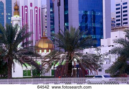 Stock Image - Palm trees near mosque and skyscrapers, Abu Dhabi, United Arab Emirates . Fotosearch