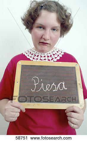 Stock Image - Portrait of girl holding slate and grimacing . Fotosearch