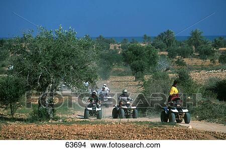Quad bikers racing on dirt road, Djerba, Tunisia View Large Photo Image Picture - Quad bikers racing on dirt road, Djerba, Tunisia . Fotosearch