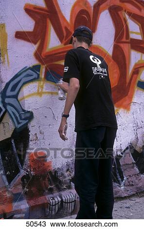 Rear view of man drawing graffiti on wall View Large Photo Image Stock Image - Rear view of man drawing graffiti on wall . Fotosearch