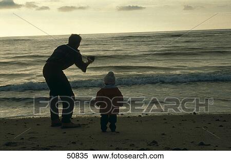 Rear view of man playing his baby on beach View Large Photo Image Stock Photography - Rear view of man playing his baby on beach . Fotosearch
