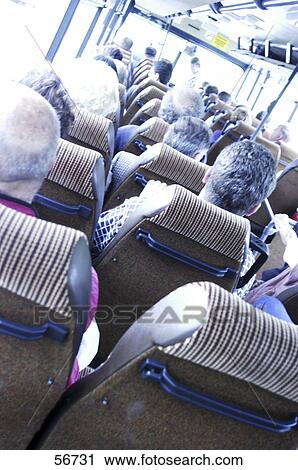 Stock Image - Rear view of passengers sitting in bus . Fotosearch