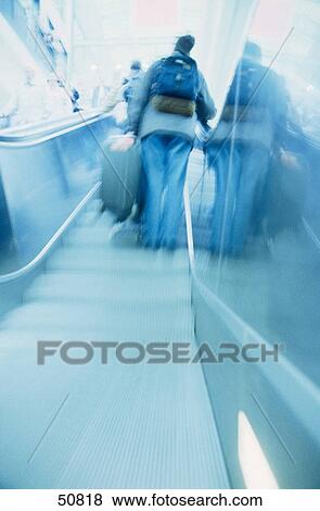 Rear view of woman with baggage on escalator View Large Photo Image Stock Photo - Rear view of woman with baggage on escalator . Fotosearch