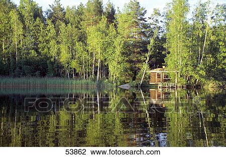 Reflection of wooden house and trees in lake, Sweden View Large Photo Image Stock Image - Reflection of wooden house and trees in lake, Sweden . Fotosearch