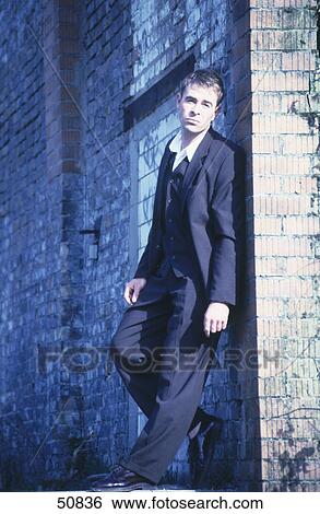 Side profile of businessman leaning against wall and looking serious View Large Photo Image Stock Photograph - Side profile of businessman leaning against wall and looking serious . Fotosearch