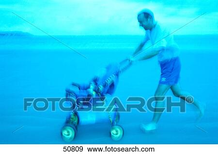 Side profile of man pushing pram on beach View Large Photo Image Stock Photo - Side profile of man pushing pram on beach . Fotosearch
