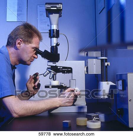 Side profile of scientist looking through microscope in laboratory View Large Photo Image Stock Photo - Side profile of scientist looking through microscope in laboratory . Fotosearch